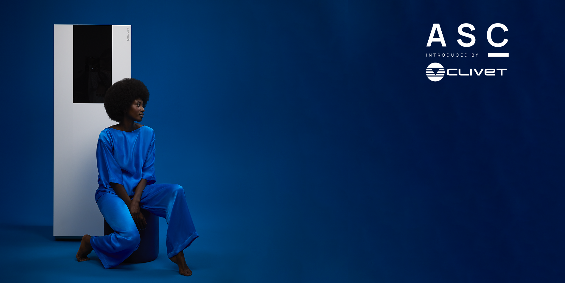 ALL SEASONS COLLECTION, una collezione di moda da casa per dimostrare che il comfort inizia con quello che ti circonda. Ambientazione blu, ragazza seduta con alle spalle una pompa di calore Clivet.